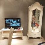 Aparador con televisión, vitrina y mesa en tonos beige, acompañado de un parquet impecable para un salón clásico