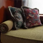 Rincón de ventana con un banco acolchado integrado, perfecto para sentarse y relajarse en el despacho