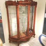 Vitrina de madera trabajada con detalle, perfecta para un ambiente clásico y elegante